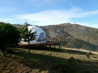 緑豊かな丘の中腹に座る白いドーム