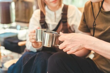 コーヒーカップを持つ男女